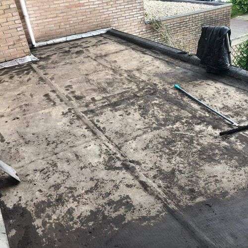 Schoonmaken van een plat dak in Bergschenhoek